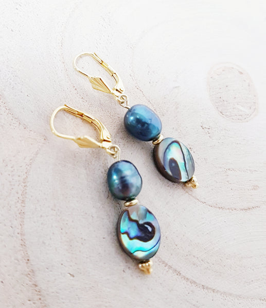 Gouden oorbellen met ovale stukjes parelmoer en blauwe parels